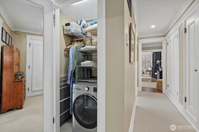 clothes washing area with light colored carpet, laundry area, ornamental molding, and washer / clothes dryer