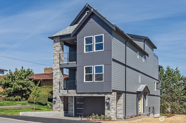 8536 S 114th St, Seattle, WA 98178 - view of home's exterior with an attached garage, stone siding, and a balcony