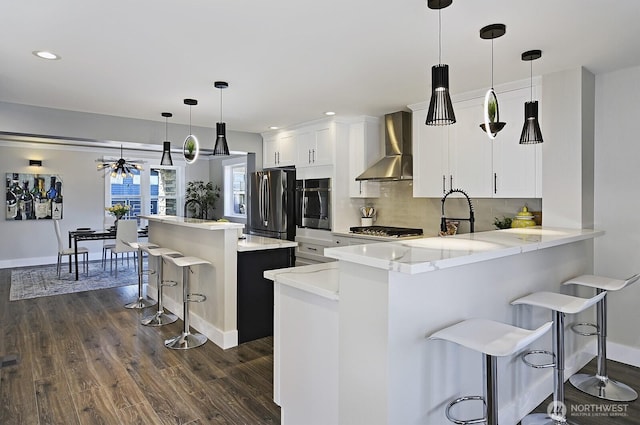 8536 S 114th St, Seattle, WA 98178 - kitchen featuring baseboards, wall chimney range hood, dark wood-style floors, a kitchen bar, and stainless steel appliances