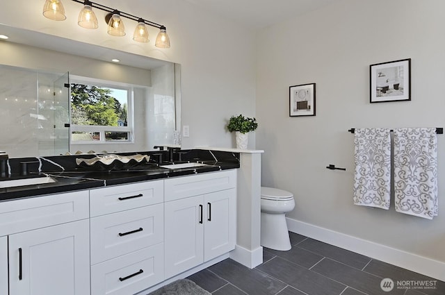 8536 S 114th St, Seattle, WA 98178 - bathroom with baseboards, double vanity, a stall shower, toilet, and a sink