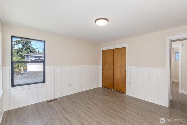 200 Priest Point Dr NE, Tulalip, WA 98271 - unfurnished room with visible vents, wood finished floors, and wainscoting
