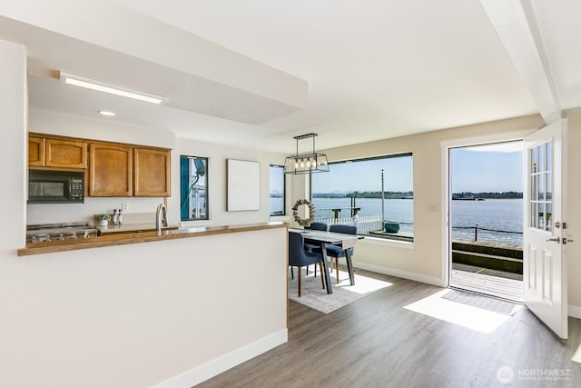 200 Priest Point Dr NE, Tulalip, WA 98271 - kitchen featuring brown cabinetry, black microwave, baseboards, and wood finished floors
