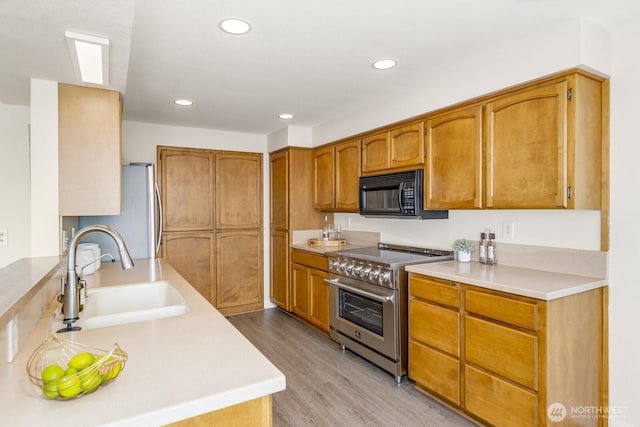 200 Priest Point Dr NE, Tulalip, WA 98271 - kitchen with a sink, appliances with stainless steel finishes, recessed lighting, light countertops, and light wood-style floors