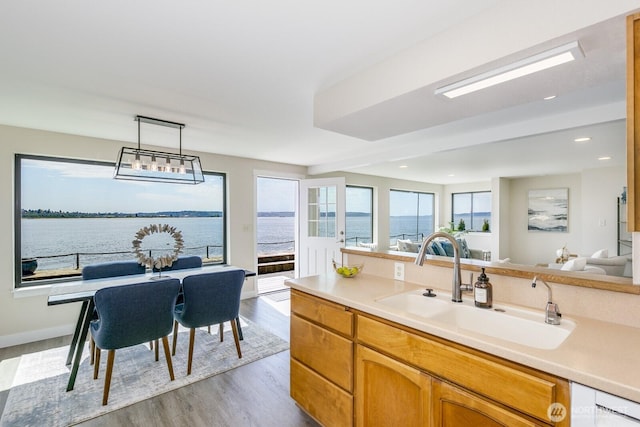 200 Priest Point Dr NE, Tulalip, WA 98271 - kitchen featuring a sink, wood finished floors, decorative light fixtures, dishwashing machine, and light countertops