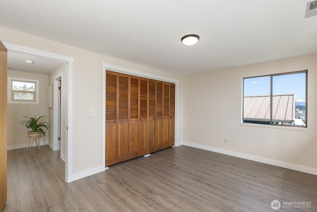 200 Priest Point Dr NE, Tulalip, WA 98271 - unfurnished bedroom featuring a closet, baseboards, and wood finished floors