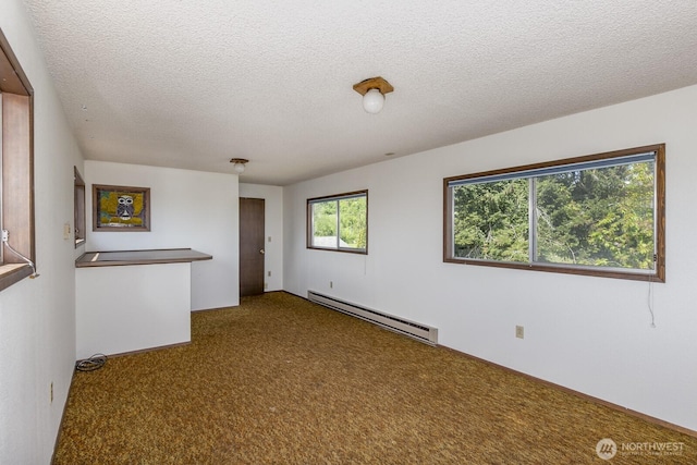200 Priest Point Dr NE, Tulalip, WA 98271 - carpeted empty room featuring a textured ceiling and a baseboard heating unit