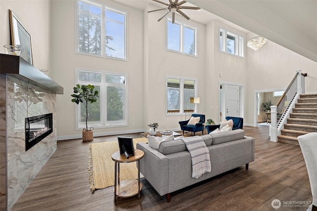 3711 S 349th Pl, Auburn, WA 98001 - living room featuring dark wood-style flooring, a high ceiling, a high end fireplace, and stairs
