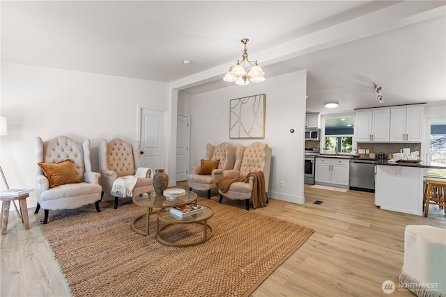 living room featuring an inviting chandelier and light wood-style floors
