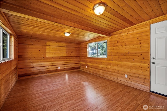 spare room with vaulted ceiling, wood finished floors, wooden walls, and wooden ceiling