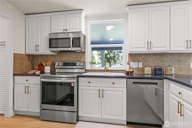 kitchen featuring a sink, white cabinetry, appliances with stainless steel finishes, and light wood finished floors