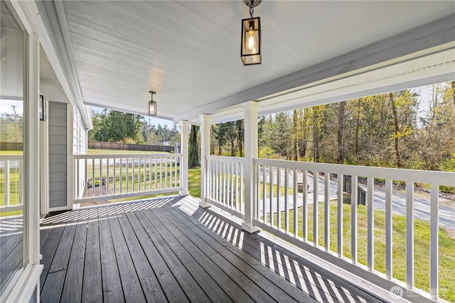 wooden deck with covered porch and a yard