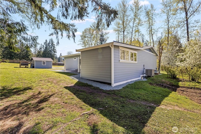 exterior space with an outdoor structure, central air condition unit, and a yard
