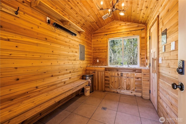 interior space featuring wood walls, an inviting chandelier, and vaulted ceiling