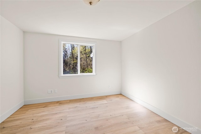 unfurnished room featuring baseboards and wood finished floors