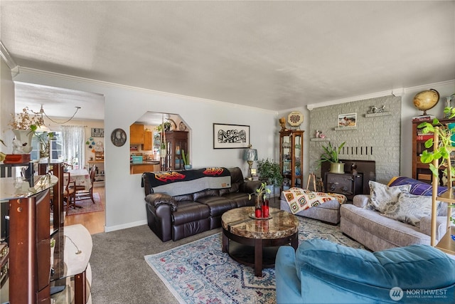 6507 Karjala Rd, Aberdeen, WA 98520 - living room featuring crown molding, carpet floors, arched walkways, baseboards, and a wood stove
