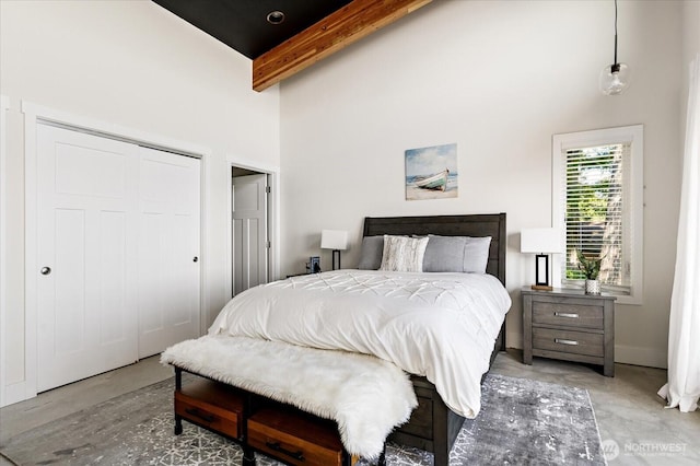 bedroom featuring a closet, concrete flooring, beam ceiling, and high vaulted ceiling