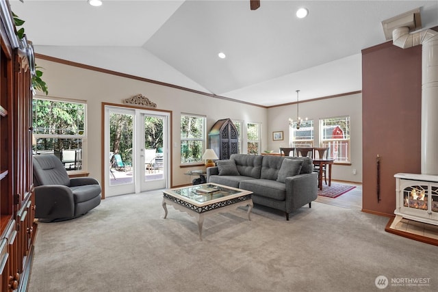 carpeted living room with recessed lighting, an inviting chandelier, vaulted ceiling, a wood stove, and ornamental molding