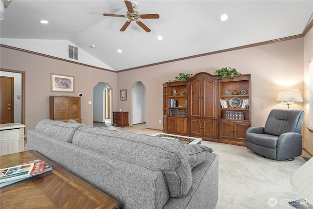 bedroom with vaulted ceiling, arched walkways, light carpet, ornamental molding, and visible vents