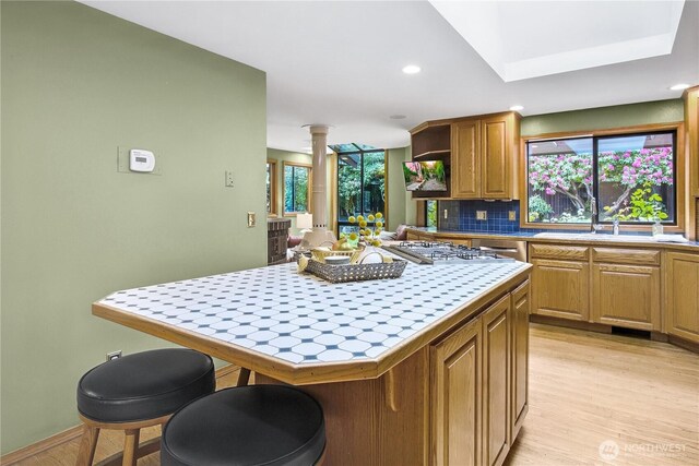 806 Alpine Dr, Everett, WA 98203 - kitchen with tile countertops, a kitchen island, decorative columns, open shelves, and light wood finished floors