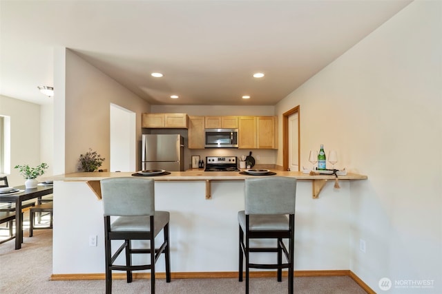 382 NE Ohenry Ct, Poulsbo, WA 98370 - kitchen with recessed lighting, light brown cabinetry, stainless steel appliances, a peninsula, and a breakfast bar area