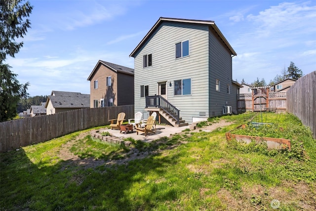 382 NE Ohenry Ct, Poulsbo, WA 98370 - rear view of house featuring a fire pit, central air condition unit, a lawn, and a vegetable garden