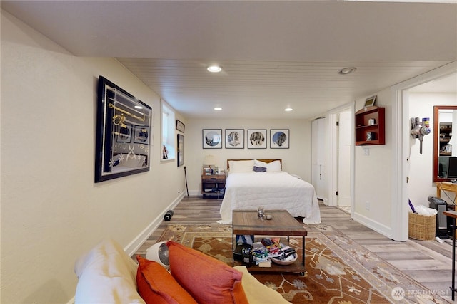 bedroom featuring baseboards, wood finished floors, and recessed lighting