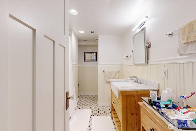 bathroom with vanity, tile patterned floors, baseboards, and wainscoting