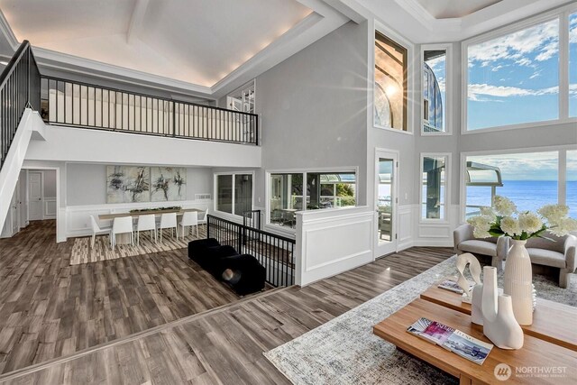 8001 Talbot Rd, Edmonds, WA 98026 - living room with high vaulted ceiling, a decorative wall, wood finished floors, a water view, and wainscoting