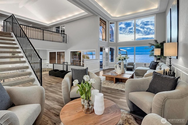 8001 Talbot Rd, Edmonds, WA 98026 - living area featuring a high ceiling, wood finished floors, stairway, and a water view