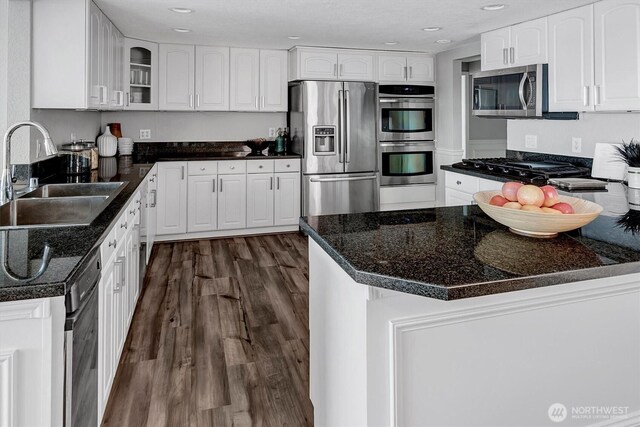 8001 Talbot Rd, Edmonds, WA 98026 - kitchen featuring black appliances, dark wood finished floors, glass insert cabinets, white cabinetry, and recessed lighting