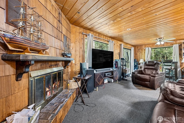 100 N Duckabush Dr W, Hoodsport, WA 98548 - carpeted living area featuring a glass covered fireplace, wooden walls, wood ceiling, and ceiling fan