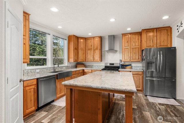 kitchen featuring a sink, wall chimney range hood, dark wood finished floors, and stainless steel appliances