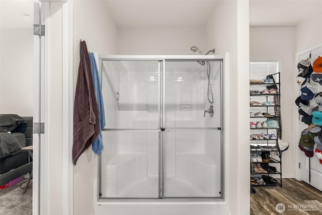 bathroom with a shower stall and wood finished floors