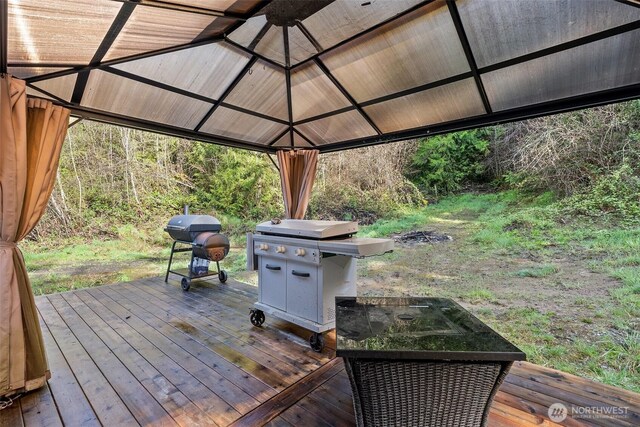 wooden terrace with a grill and a gazebo