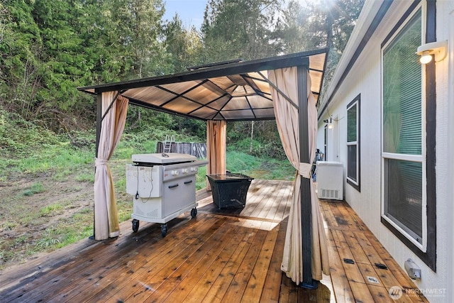 wooden terrace with a gazebo and area for grilling