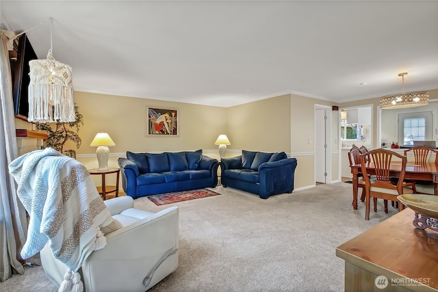 living room with crown molding, carpet floors, baseboards, and a chandelier