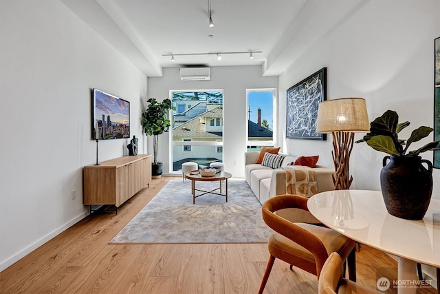 1233 E Roy St, Seattle, WA 98102 - living area with light wood-style flooring, track lighting, baseboards, and an AC wall unit