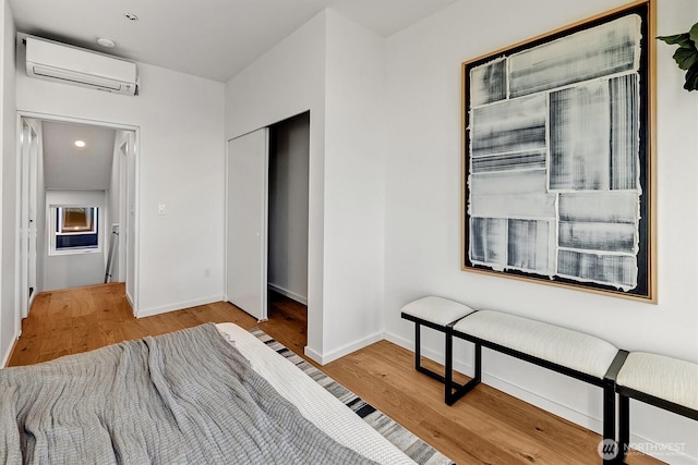 1233 E Roy St, Seattle, WA 98102 - bedroom featuring a closet, baseboards, a wall mounted AC, recessed lighting, and wood finished floors