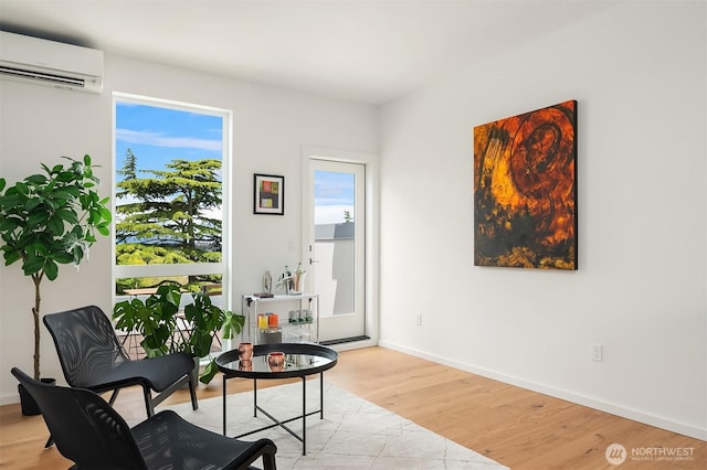 1233 E Roy St, Seattle, WA 98102 - living area featuring light wood-style flooring, a wall mounted air conditioner, baseboards, and a wealth of natural light