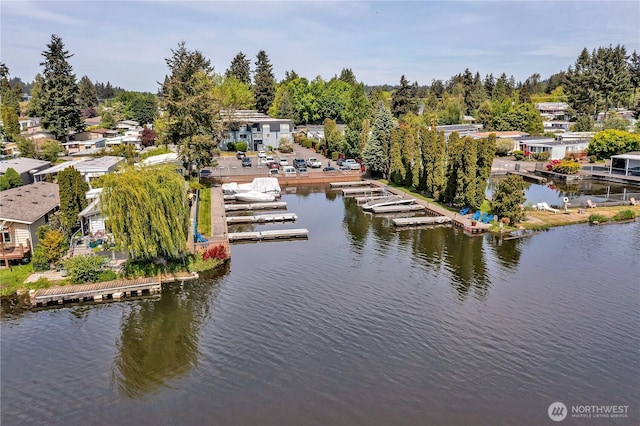 drone / aerial view of a nearby body of water and a tree filled landscape