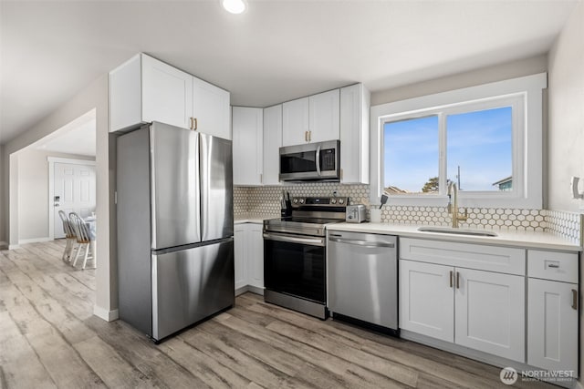 34 4th St S, Pacific Beach, WA 98571 - kitchen with light countertops, white cabinetry, backsplash, appliances with stainless steel finishes, and a sink