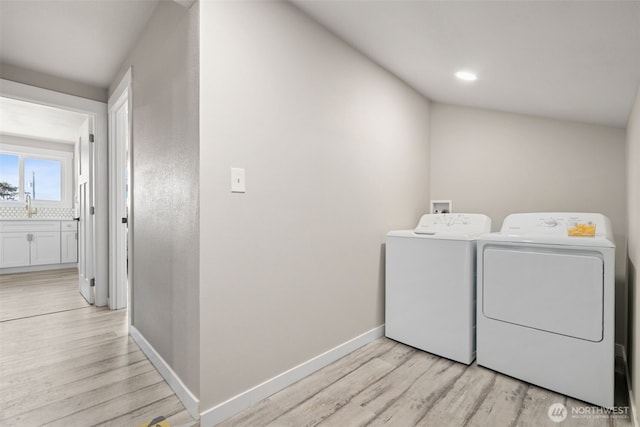34 4th St S, Pacific Beach, WA 98571 - washroom with a sink, light wood-type flooring, separate washer and dryer, and laundry area