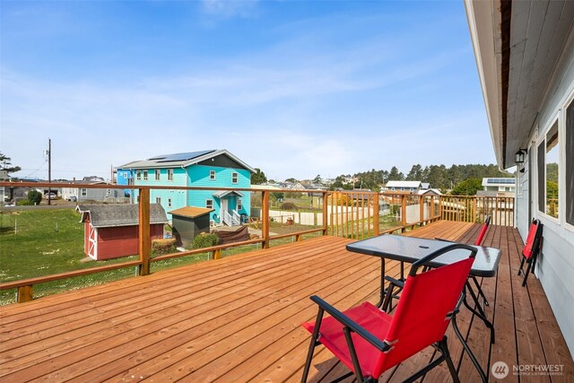 34 4th St S, Pacific Beach, WA 98571 - wooden terrace featuring an outbuilding, a storage unit, a residential view, and a yard