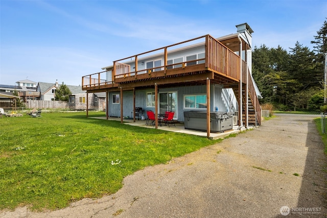 34 4th St S, Pacific Beach, WA 98571 - back of property with a hot tub, a yard, a patio area, fence, and stairs