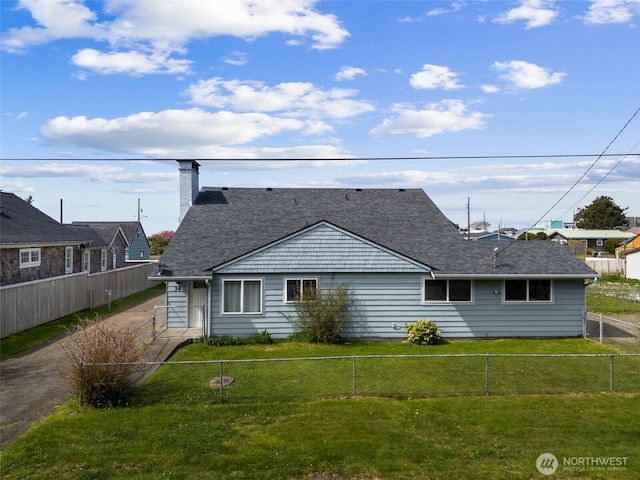34 4th St S, Pacific Beach, WA 98571 - back of house featuring a yard, a fenced backyard, a shingled roof, and a chimney