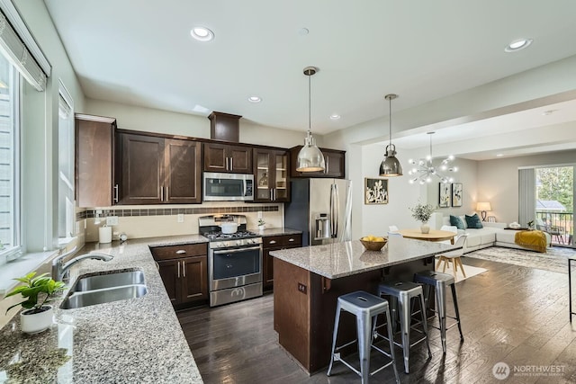 2546 NE Mulberry Walk, Issaquah, WA 98029 - kitchen with stainless steel appliances, a kitchen breakfast bar, a sink, open floor plan, and dark brown cabinetry