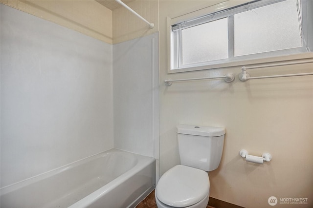 full bath with toilet, washtub / shower combination, and baseboards