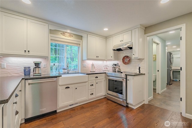 13501 NE 228th Ct, Brush Prairie, WA 98606 - kitchen featuring stainless steel appliances, under cabinet range hood, a sink, dark wood-type flooring, and white cabinetry