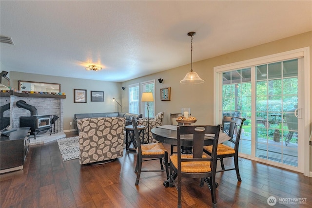 13501 NE 228th Ct, Brush Prairie, WA 98606 - dining area with a wood stove, dark wood finished floors, and baseboards