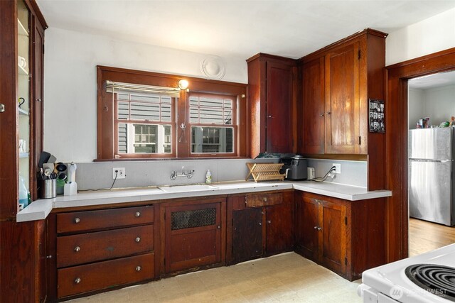 5019 17th Ave NE, Seattle, WA 98105 - kitchen with light countertops, freestanding refrigerator, white electric range, light floors, and a sink